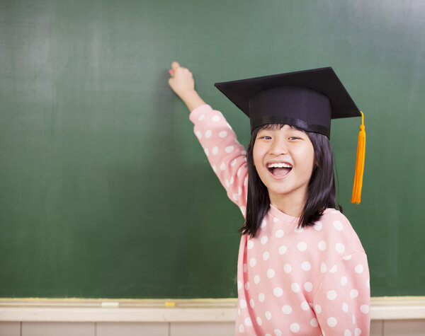 happy little girl wear a graduation hat with blackboard