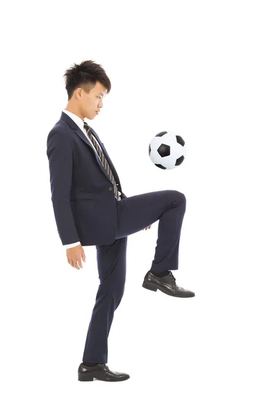 Hombre de negocios está pateando un fútbol —  Fotos de Stock