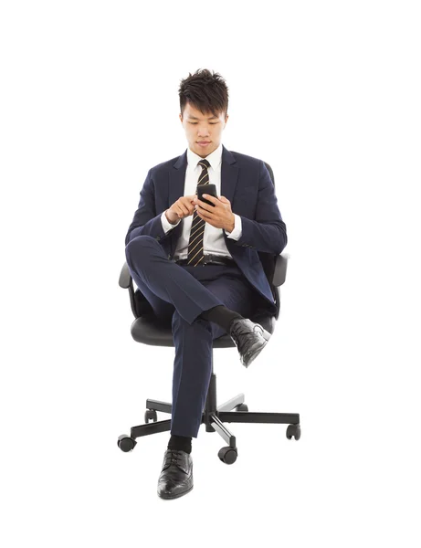 Asian businessman touching smart phone on chair — Stock Photo, Image