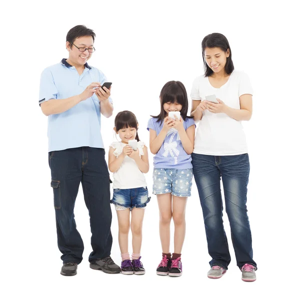 Familie permanent een rij en met behulp van slimme telefoon samen — Stockfoto