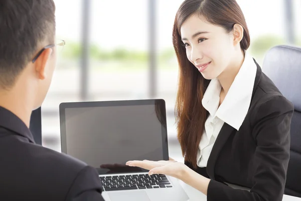 Glimlachende zakenvrouw weergegeven op laptop en een uitleg van een plan — Stockfoto