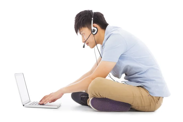 Ung man koppla av på golvet och lyssnar på musik — Stockfoto