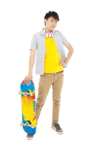 Selbstbewusster junger Mann steht und hält Skateboard — Stockfoto