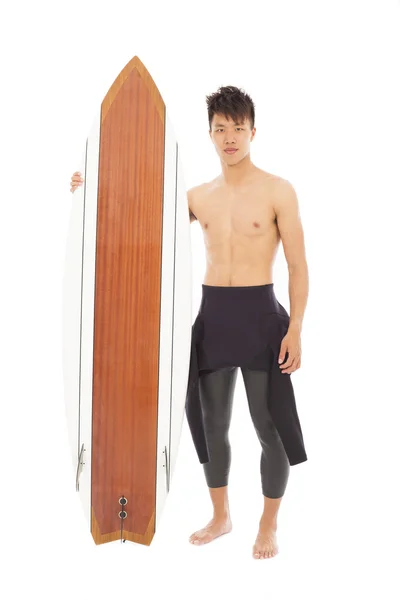 Jonge surfer dragen duikpak en houden van een surfplank — Stockfoto