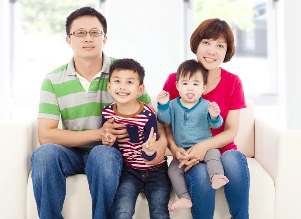 Aziatische en gelukkige familie zit op een witte lederen sofa — Stockfoto