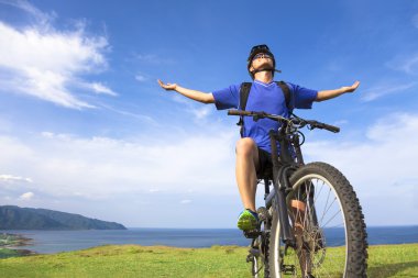 genç adam bir dağ bisikleti üzerinde oturan ve açık kollar için rahatlatıcı