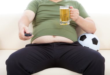 bira içip kanepede oturan şişman adam TV izlemek için