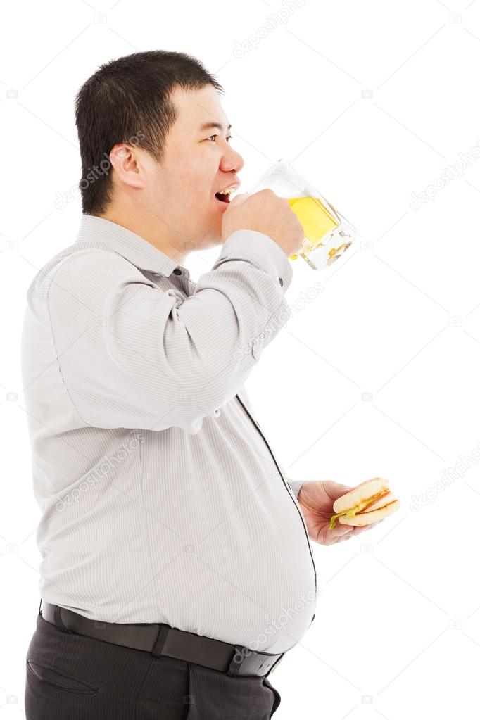 fat business man drinking beer mug and eating hamburger