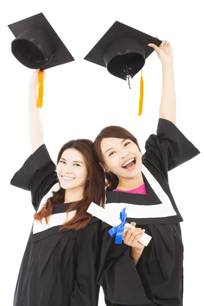 Deux jeunes diplômés heureux tenant chapeaux et diplôme — Photo