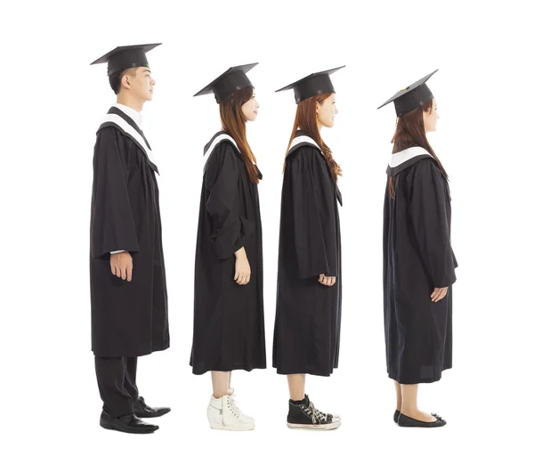 Estudiantes graduados de pie una row.isolated en blanco — Foto de Stock