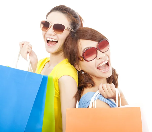 Young sisters holding shopping bags and Back to back — Stock Photo, Image