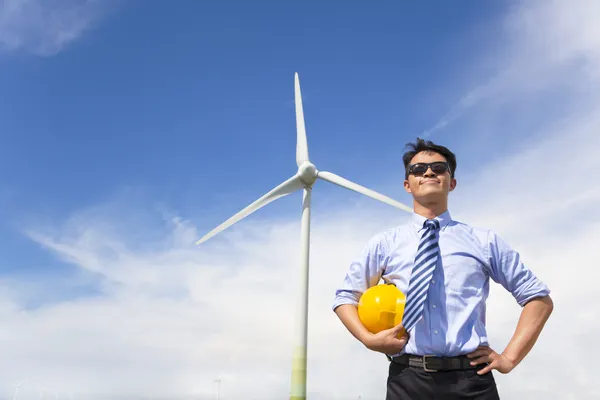 Профессиональный молодой инженер, стоящий с ветрогенератором — стоковое фото