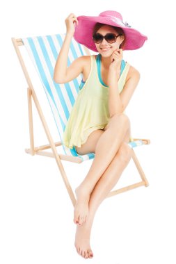 gülümseyen ve plaj sandalye üzerinde oturan genç güneş kız