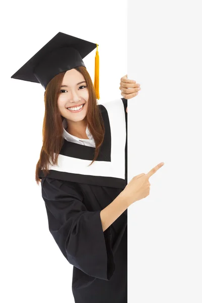 Jovens estudantes de graduação do sexo feminino apontam para placa em branco — Fotografia de Stock