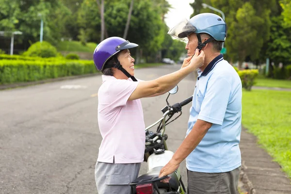 Nonna felice aiutare il nonno a indossare un casco — Foto Stock