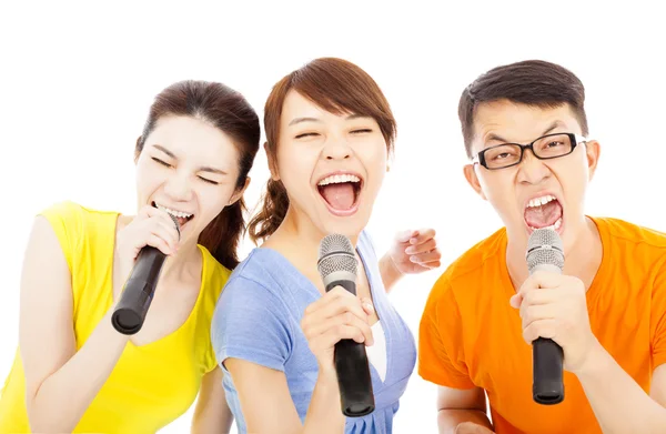 Grupo jovem feliz se divertindo cantando com karaoke — Fotografia de Stock