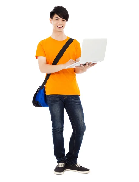 Confident young student standing and using laptop — Stock Photo, Image