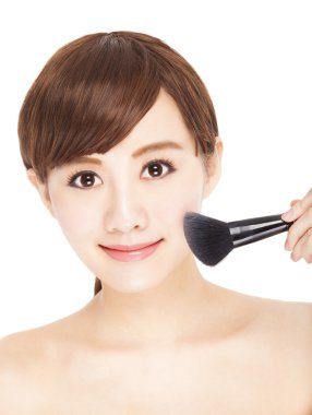 kullanan genç ve güzel kadın yüzüne makyaj fırçaları 