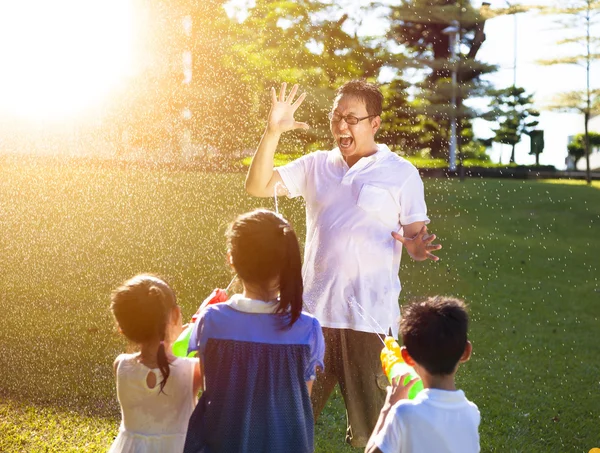 Lilla barnet spray vatten till far tillsammans av vatten kanoner — Stockfoto