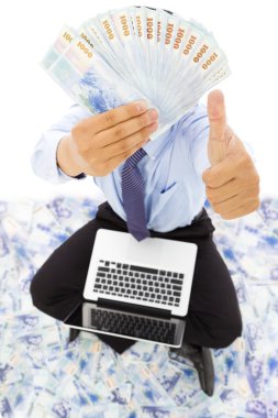 Happy business man showing the money and thumb up clipart