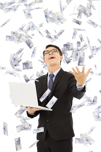 Happy business man holding a laptop and  catching money — Stock Photo, Image