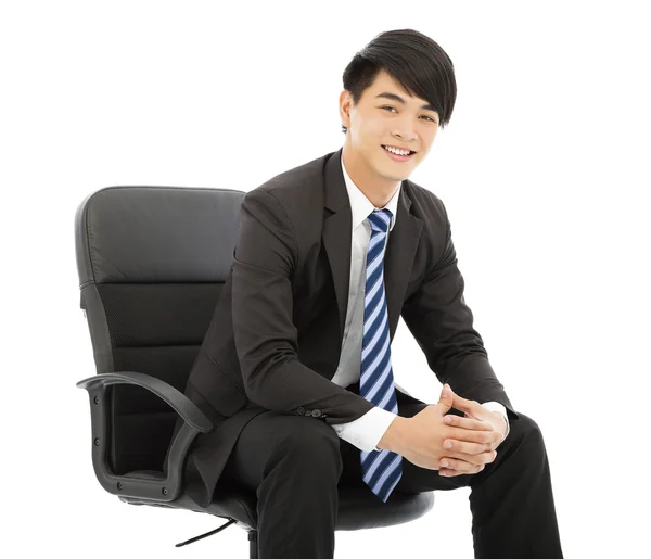 Усміхнений молодий бізнесмен сидить у кріслі — стокове фото
