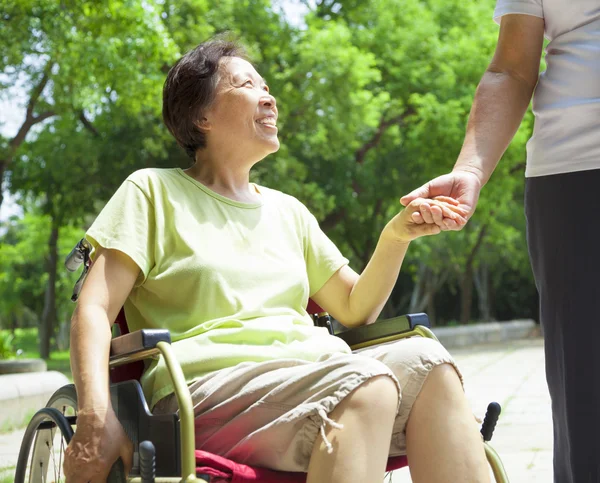 Senior man met haar handicap vrouw op rolstoel — Stockfoto