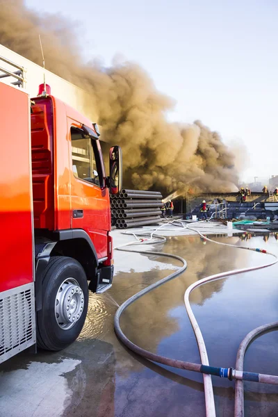 Moteur d'incendie avec le fond d'incendie de l'usine — Photo