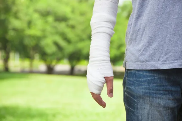 Närbild av bandagerade arm med park bakgrund — Stockfoto