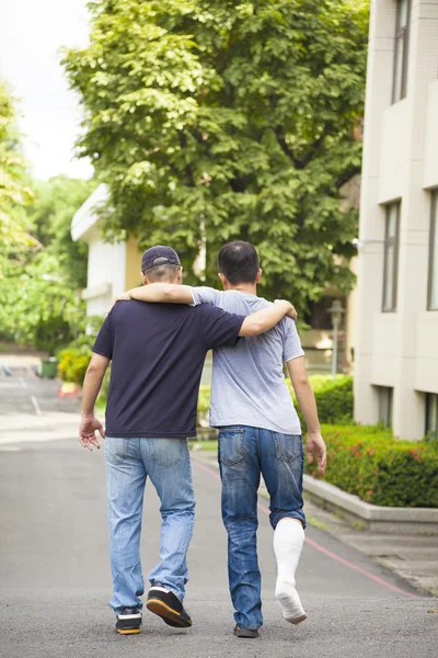 Friend helping brothers or patient  to walk without crutches — Stock Photo, Image