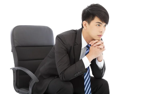 Jeune homme d'affaires réfléchissant et assis sur une chaise — Photo