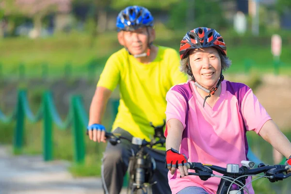 Szczęśliwa Para Seniorów Trenująca Rowerach Parku — Zdjęcie stockowe