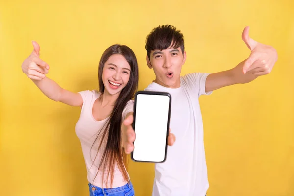 兴奋的年轻夫妇指着空白的智能手机屏幕 — 图库照片