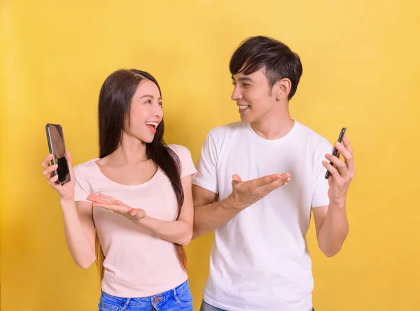 スマートフォンの画面を示す幸せな若いカップル — ストック写真