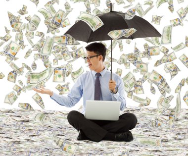 Doları yağmur şemsiye tutan genç iş adamı