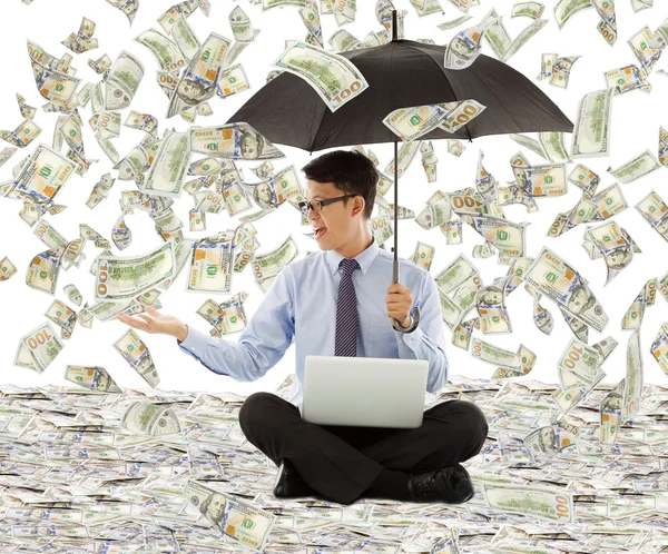 Junger Geschäftsmann hält einen Regenschirm mit Dollarregen — Stockfoto