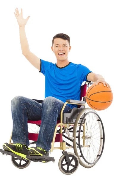 Junger Mann sitzt im Rollstuhl und hält einen Basketball — Stockfoto