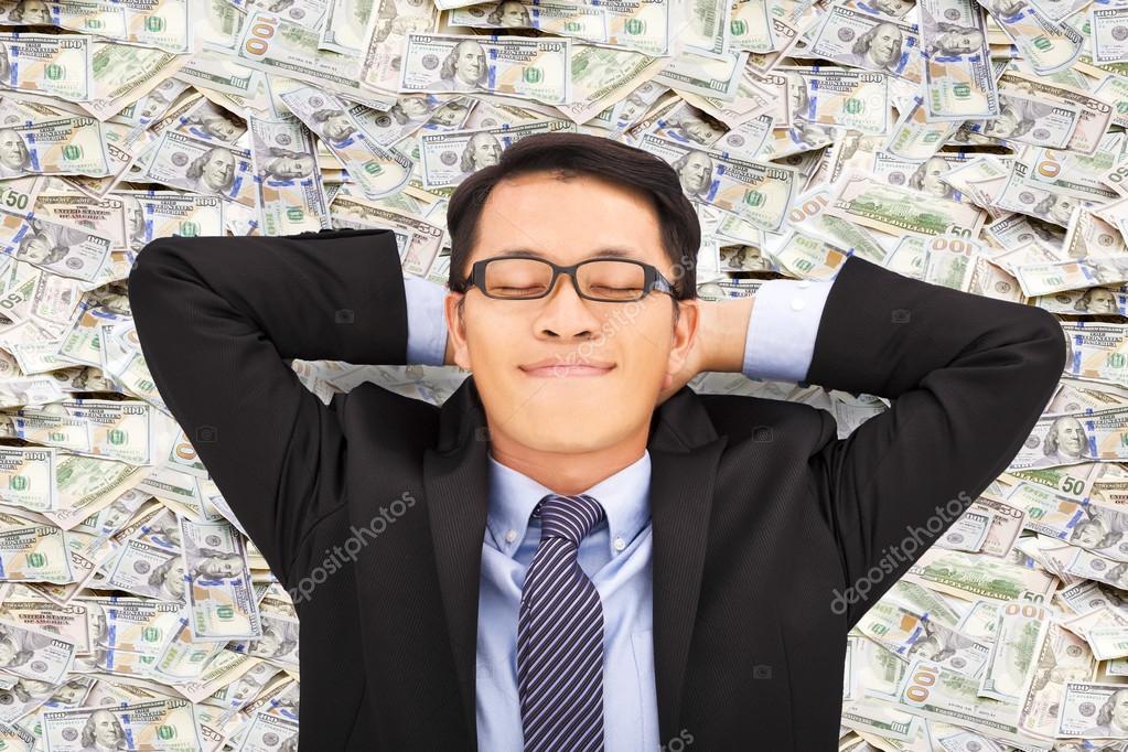 business man enjoying and lying on the money