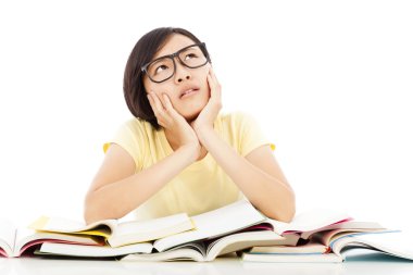 Genç öğrenci kız masanın üzerinde kitap ile düşünme