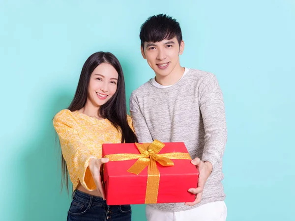 Glückliches Junges Paar Zeigt Geschenk Isoliert Auf Blauem Hintergrund — Stockfoto