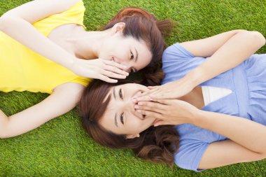 iki Asyalı kız Gossip çimde fısıldayan