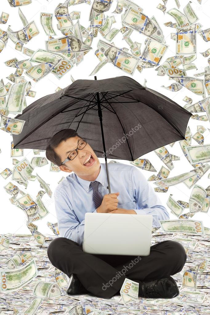 happy business man sitting on floor with us dollar rain
