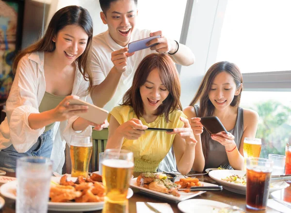 Yemekten Önce Akıllı Telefonla Fotoğraf Çeken Mutlu Genç Bir Grup — Stok fotoğraf