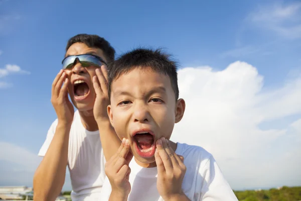 Padre e figlio fanno una smorfia insieme nel parco — Foto Stock