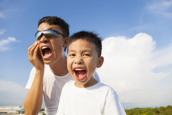 Padre e hijo haciendo una mueca juntos en el parque — Foto de Stock