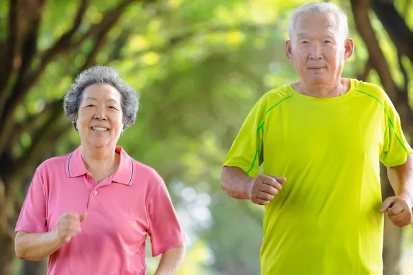 快乐的亚洲老年人夫妇在公园里慢跑 — 图库照片