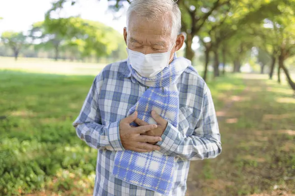 Homem Sênior Vestindo Máscara Médica Segurando Peito Com Dor — Fotografia de Stock