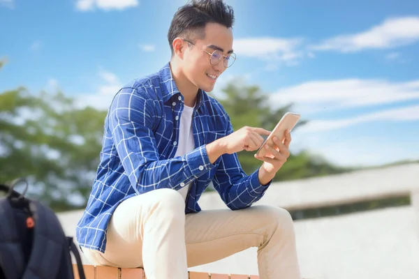 Pria Asia Muda Tersenyum Duduk Tangga Dan Menggunakan Telepon Pintar — Stok Foto