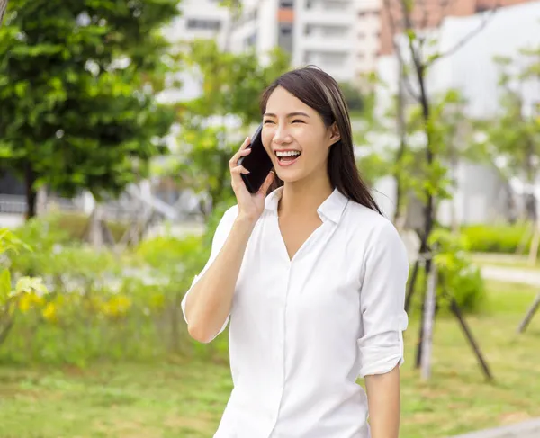 兴奋的亚洲年轻女子在手机上说话 — 图库照片