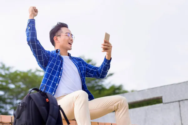 Opgewonden Jonge Aziatische Man Zitten Trap Met Behulp Van Smart — Stockfoto